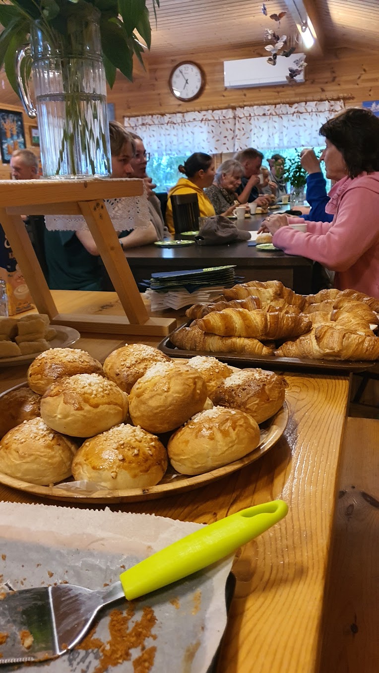 Kahvittelijoiden edustalla croissanteja ja pullaa tarjoiluastioissa.